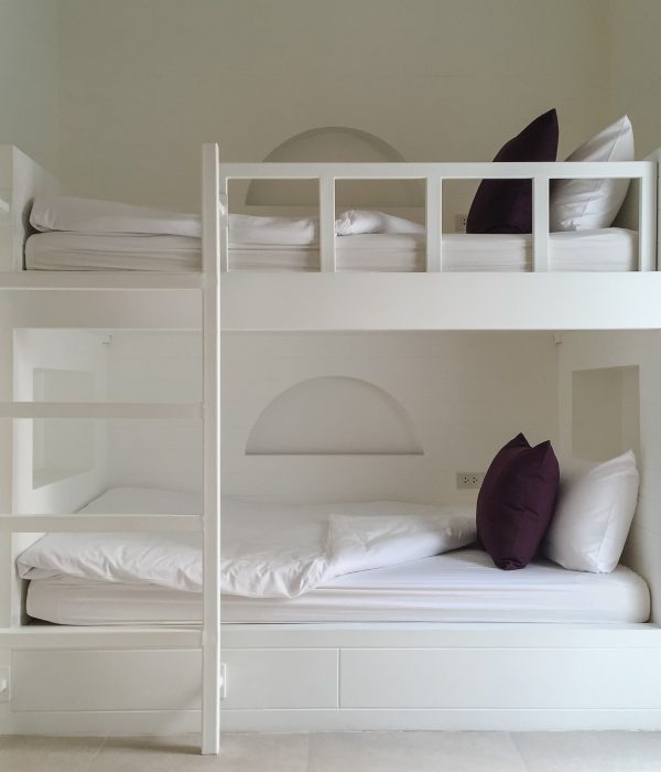 Clean hotel room with wooden bunk beds. Vintage effect style pictures.